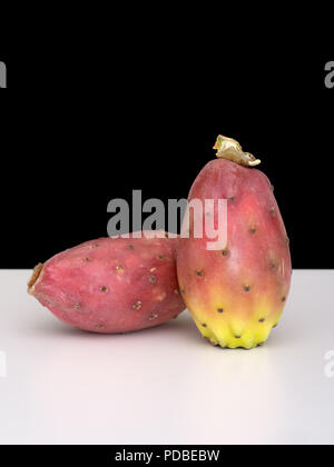 Two Indian aka Barbary figs, Opuntia ficus-indica on white with black background. Aka Prickly pear, Tuna fruit. Stock Photo