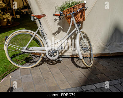 a old fashioned white bicycle propped up against a white backdrop Stock Photo