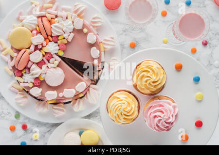 top view of birthday cake with marshmallows, cupcakes and milkshakes on table Stock Photo