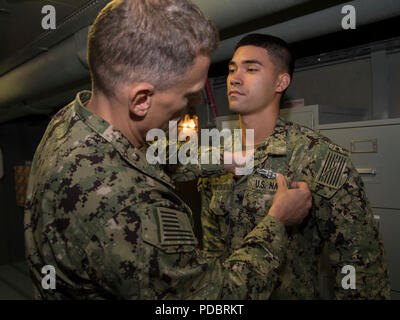NEWPORT NEWS, Va. (Aug. 3, 2018) Cryptologic Technician (Technical) 2nd Class MichaelJoseph ThompsonGuevara, from San Diego, assigned to USS Gerald R. Ford (CVN 78), receives his Enlisted Information Warfare Specialist pin from Senior Chief Intelligence Specialist Michael Linares. (U.S. Navy photo by Mass Communication Specialist 2nd Class Cat Campbell)