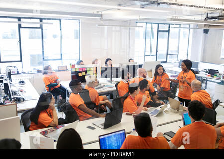 Hackers coding for charity at hackathon Stock Photo