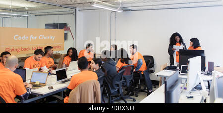 Hackers coding for charity at hackathon Stock Photo