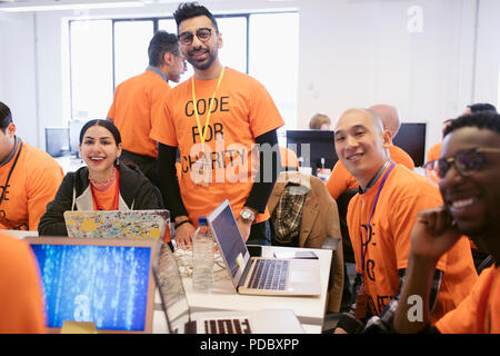 Portrait confident hackers coding for charity at hackathon Stock Photo