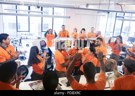 Hackers celebrating, coding for charity at hackathon Stock Photo