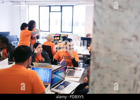 Hackers coding for charity at hackathon Stock Photo