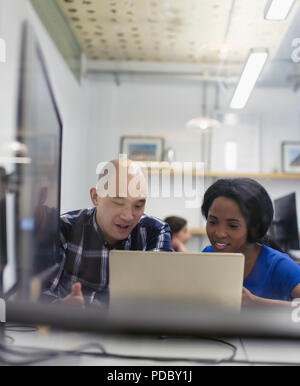 Businessman and businesswoman using laptop in office Stock Photo