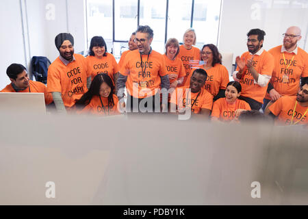 Hackers coding for charity at hackathon Stock Photo