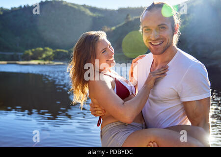 Portrait romantic, carefree couple at sunny summer lake Stock Photo