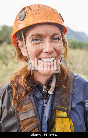Portrait smiling, muddy woman zip lining Stock Photo