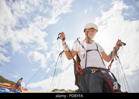 Mature male paraglider preparing equipment Stock Photo