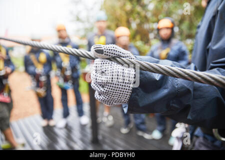 Woman in glove holding zip line Stock Photo