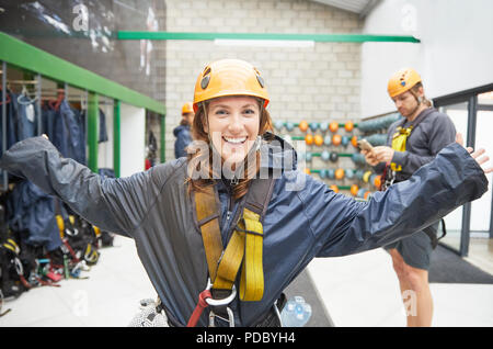 Portrait smiling, confident young woman preparing zip line equipment Stock Photo