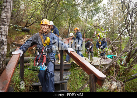 Portrait smiling woman preparing to zip line Stock Photo