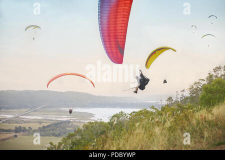 Paragliders in sky over landscape Stock Photo