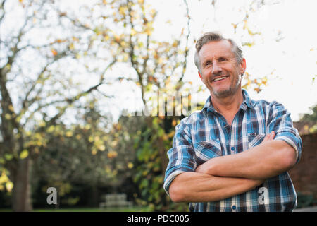 Portrait confident mature man in autumn backyard Stock Photo