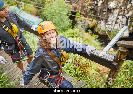 Portrait smiling woman preparing to zip line Stock Photo