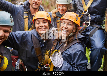 Portrait happy, muddy friends zip lining Stock Photo