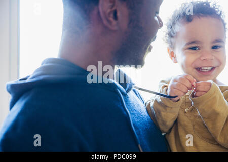 Portrait father holding cute, smiling baby son Stock Photo