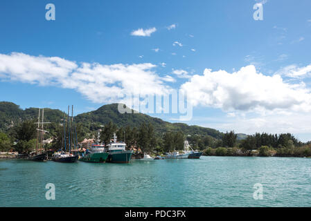 Multiple motor and sailing boats anchoring in the port of Praslin, Seychelles Stock Photo