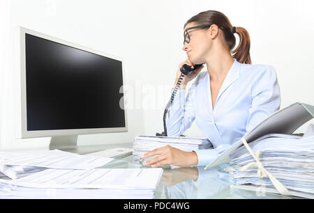 business woman working at office desk with computer and documents speak on the phone and look at an empty monitor, isolated on white background Stock Photo