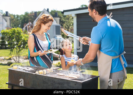 Nice pleasant man holding sausages Stock Photo
