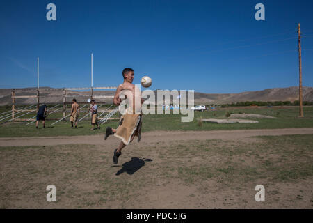 Buryat men play football near sacred mountain Erd located 2 km from Baikal lake, Irkutsk oblast, Russia Stock Photo