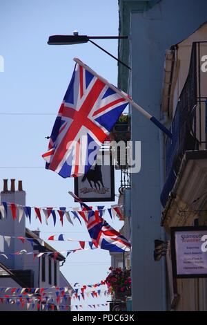 Union Jack Flags and Bunting Decorate a Town Street against a Blue Summer Sky. Sidmouth Folk Festival, East Devon, UK. August, 2018. Stock Photo