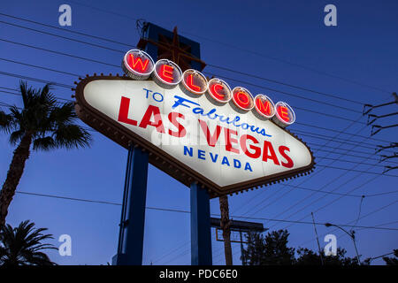 Welcome to Fabulous Las Vegas sign, palm trees and overhead wire grid at night. Stock Photo