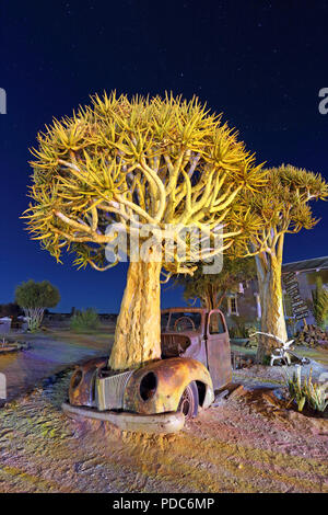 A wrecked 1940s Ford pickup truck photographed under a mixture of artificial light and moonlight at the Canyon Roadhouse, Namibia. Stock Photo