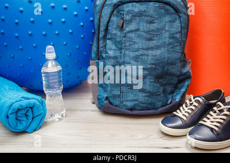 Different tools for fitness in room or gym on grey floor Stock Photo