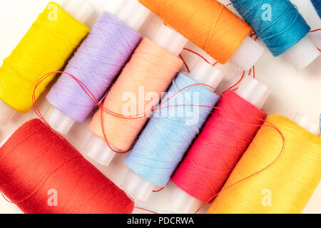 An overhead closeup photo of vibrant sewing thread spools in different colors Stock Photo