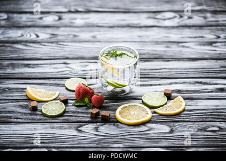 fresh cold lemonade in glass and ripe ripe strawberries on wooden table Stock Photo