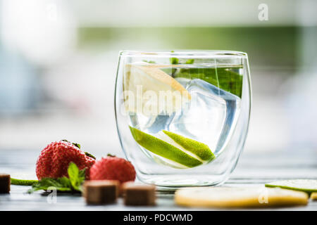 close-up view of fresh cold lemonade in glass and ripe ripe strawberries on table Stock Photo