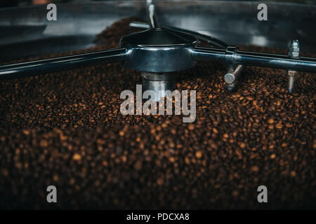 Aromatic coffee beans being roasted in professional machine Stock Photo