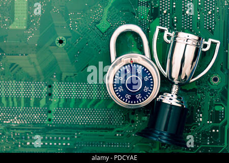 Data security expert. Padlock and trophy on a computer electronic circuit board. Stock Photo