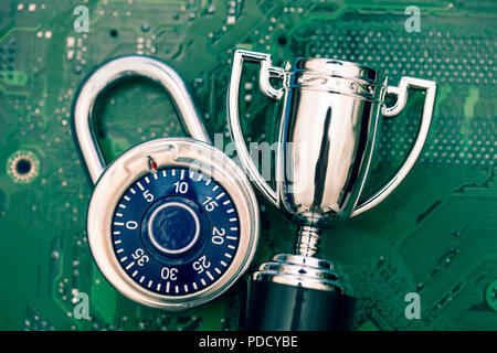 Data security expert. Padlock and trophy on a computer electronic circuit board. Stock Photo