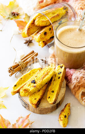 Autumn background baking. Freshly baked raisins and cinnamon biscotti and a cup of cappuccino coffee on light slate or slate background. Stock Photo