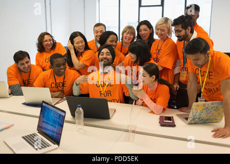Portrait confident hackers coding for charity at hackathon Stock Photo