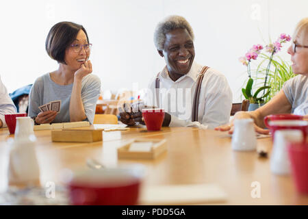 Senior friends playing games at table in community center Stock Photo