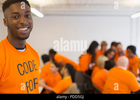 Portrait confident hacker coding for charity at hackathon Stock Photo