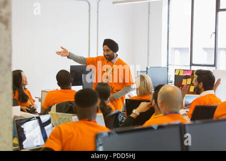 Hacker in turban leading meeting, coding for charity at hackathon Stock Photo