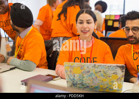 Hackers at laptop coding for charity at hackathon Stock Photo