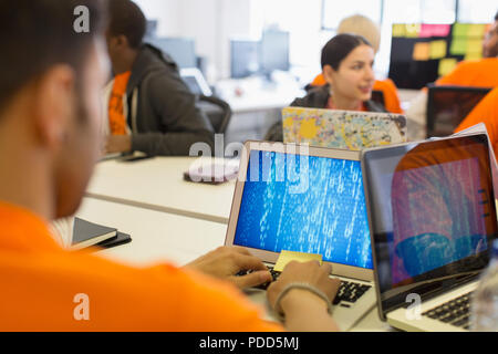 Hackers at laptops coding for charity at hackathon Stock Photo