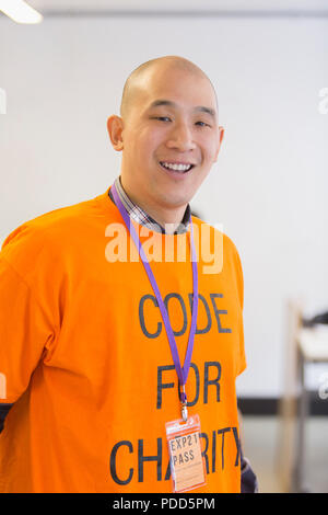 Portrait confident hacker coding for charity at hackathon Stock Photo