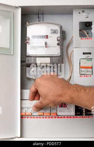 Electrical terminal box. man turn on or off Stock Photo