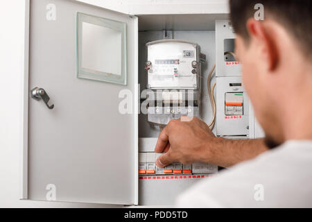 Electrical terminal box. man turn on or off Stock Photo