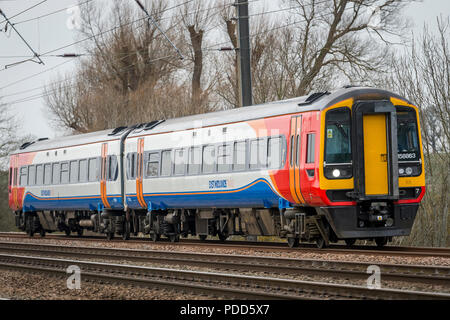 Class 158 train in East Midlands Trains livery travelling through the English countryside. Stock Photo