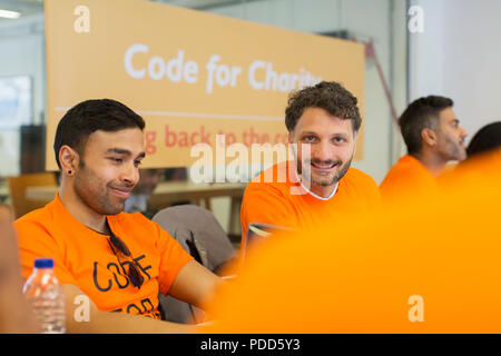 Hackers coding for charity at hackathon Stock Photo