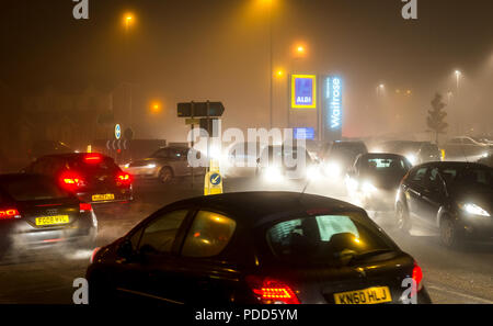 Traffic driving on a winter's night on a street in Market Harborough, England. Stock Photo