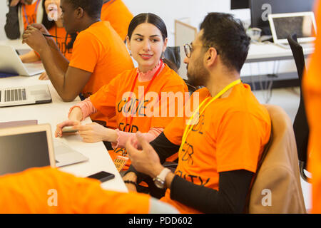 Hackers coding for charity at hackathon Stock Photo